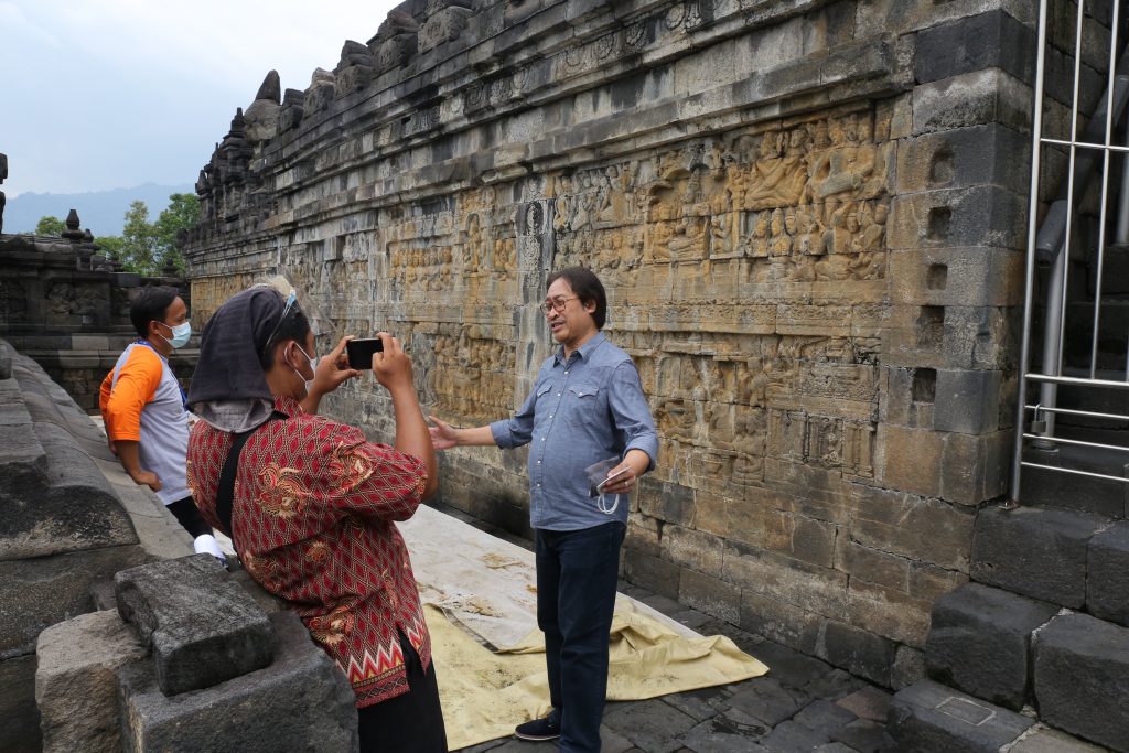 Purwacaraka melihat relief candi Borobudur yang menggambarkan berbagai macam alat musik