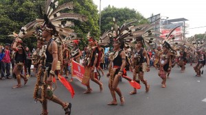 Iring-iringan orang dengan pakaian tradisional