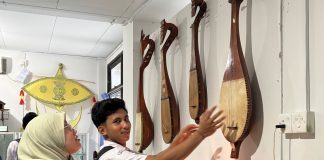 Siswa MAN Bintan sedang memperhatikan dambus (gambus) alat musik tradisional dari Kepulauan Bangka Belitung