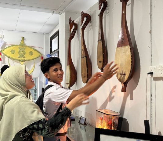 Siswa MAN Bintan sedang memperhatikan dambus (gambus) alat musik tradisional dari Kepulauan Bangka Belitung