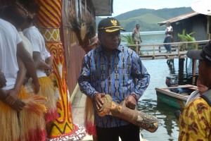 Mathius Awaitouw,MSi Bupati kabupaten Jayapura memukul tifa saat peresmian Obhe Adat Kampung Heram Ayafo