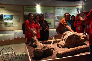 Pemandu mengajak rombongan berinteraksi dengan salah satu koleksi fosil di museum