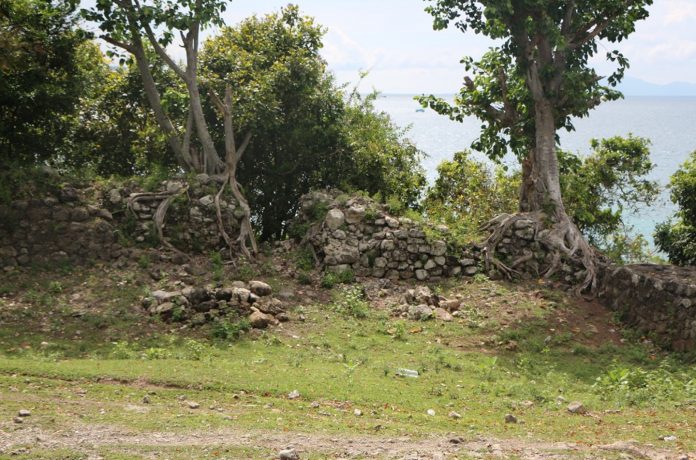 Reruntuhan benteng Inong Balee. Tampak pepohon tumbuh di atasnya, dan akarnya mengangkat struktur batu.